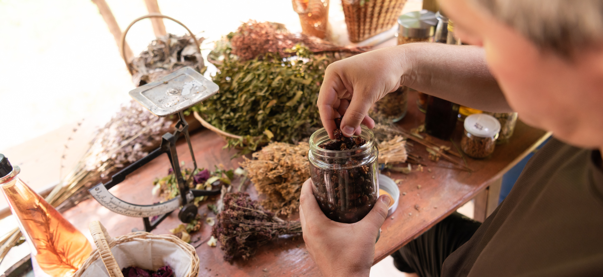 herbalist preparing dried herbs and botanicals at a work table