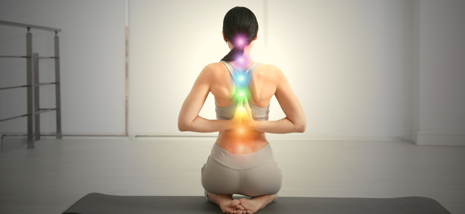 woman meditating with illustrated energy centers along her spine
